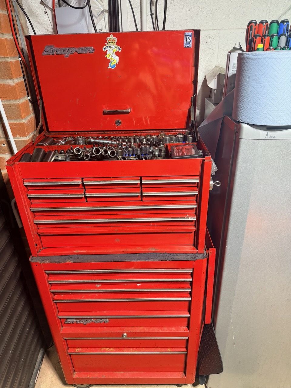Open red Snap-on toolbox and roll cabinet filled with sockets and hand tools